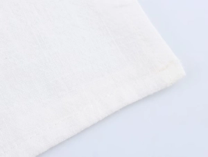 Gros plan sur la texture du lin blanc et les coutures détaillées de l'ensemble décontracté