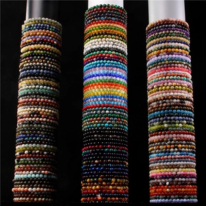 Multiple rows of colorful 6mm natural stone beaded charm bracelets on cylindrical displays
