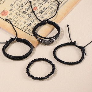 Detailed view of four-piece black leather and beaded bracelet set with metal accent