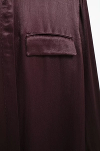 Close-up of the front pocket on this elegant burgundy satin shirt for women