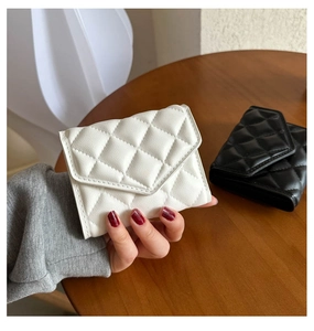 Close-up of quilted pattern faux leather small square wallet in white and black