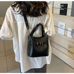 Detailed back view of a black lychee texture bucket bag with gold hardware and strap