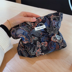 Detail of hand-held floral brocade clutch bag with colorful butterfly embroidery patterns