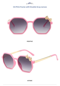 Close-up of pink polygon sunglasses with golden bow detail and gradient grey lenses