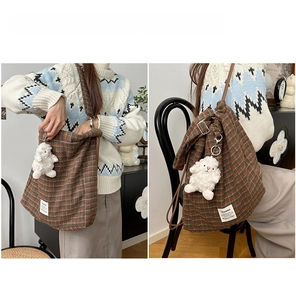 Detail of checkered plaid backpack showing shoulder and crossbody strap options