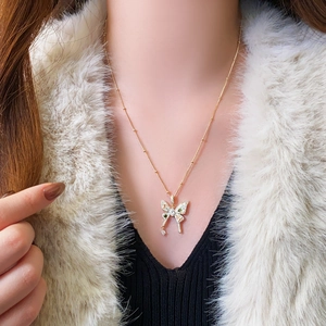 Detailed view of an elegant butterfly pendant necklace with zircon inlay on a model