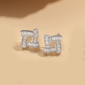 Macro view of silver geometric bow earrings with clear rectangular baguette crystals