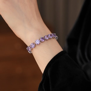 Detail of elegant silver bracelet with round purple gemstone worn on wrist