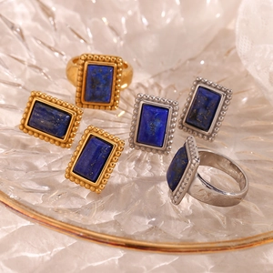 Lapis lazuli jewelry set with 18K gold-plated rings and earrings on a glass plate