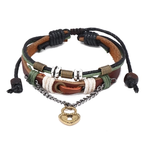 Détail d'un bracelet multicouche en cuir vintage avec charme cadenas cœur et perles