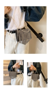 Detail of black evening clutch with silver rhinestone tassels and round metal handle