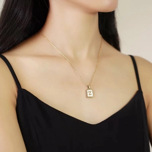 Gold letter Z necklace with rectangular pendant on model showing creative metal luster