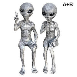 Pair of gray resin alien statues with metallic texture showing peace and shush gestures