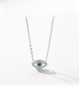 Macro detail of S925 sterling silver evil eye pendant with blue crystals and pavé stones