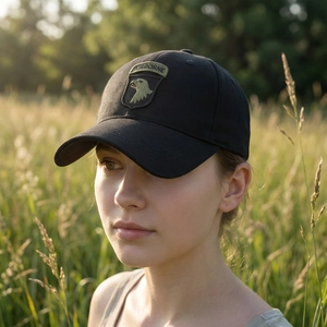 Tactical black baseball cap with 101st Airborne embroidery in outdoor sunset setting