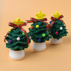 Set of three handmade crochet mini Christmas trees with colorful pom-poms and white pots