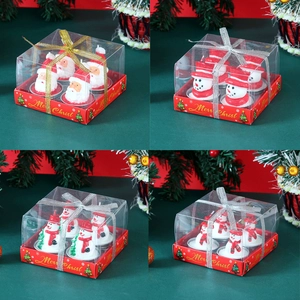 Close-up of Santa and Snowman Christmas candles in gift boxes with ribbon bows