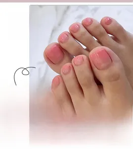 Detail of pink gradient toenail press-ons with subtle glitter finish on model