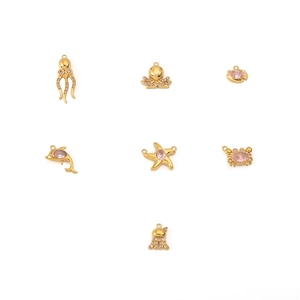 Detail of 18K gold-plated starfish and octopus charms with crystals for ocean jewelry