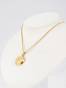 Detail of 18K gold-plated necklace featuring a round pendant with letter P and crystal