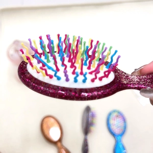 Mini pink glitter cushion hairbrush with colorful wavy bristles for portable scalp massage