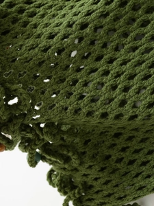 Detail view of the green knit crochet mesh fabric texture for handmade vacation set