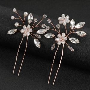 Close-up of handmade gold wire bridal hair pins with white pearls and clear crystals