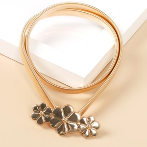 Makro-Detail der elastischen goldenen Metall-Taillenkette mit dreifacher Blumenschnalle