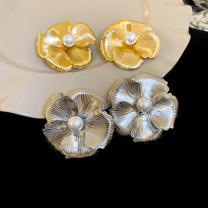 Chic oversized metal flower stud earrings with central pearl in gold and silver finish