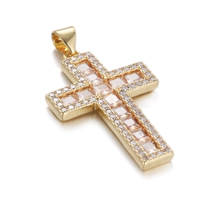 Macro view of gold-plated cross pendant featuring a pink zircon and micro-pave crystals