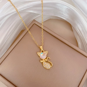 Macro shot of gold cat pendant necklace with moonstone and pavé stones on beige box