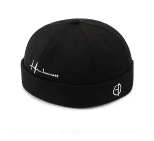 Detail view of black cotton Miki hat with white embroidery and round geometric icon