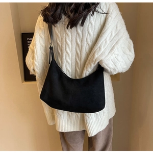 Minimalist black frosted crescent bag worn with cream knit sweater for casual styling