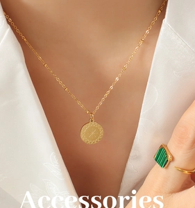 Primo piano della collana con disco solare dorato e anello in malachite su seta