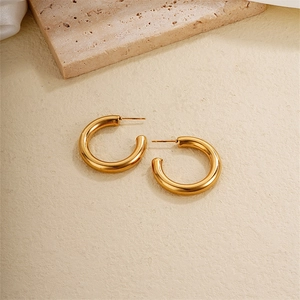 Minimalist chunky 18K gold plated titanium steel hoop earrings on a stone texture base