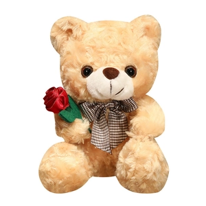 Light brown teddy bear plush with rose texture fabric holding a red rose and bow