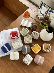 Flat lay of quilted square mini pouches for earphones and coins on a wooden desk