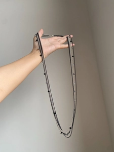 Dettaglio della collana multistrato in argento e nero con perle di cristallo trasparente