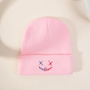 Bonnet en tricot rose avec broderie bicolore sur un fond neutre et propre