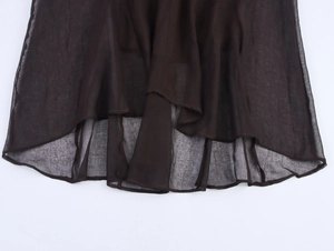 Detail of sheer chiffon fabric hem showing lightweight texture and drape of the dark dress