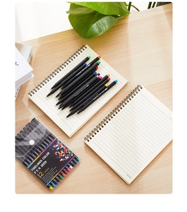 Close-up of 12-color 0.4mm fineliner pen set displayed with a notebook on a wooden desk