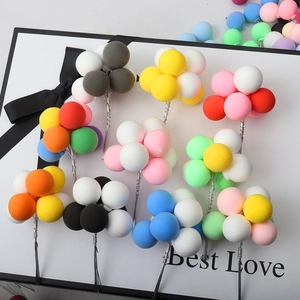 Close-up of colorful clay balloon cake toppers on a gift box for birthday party decor