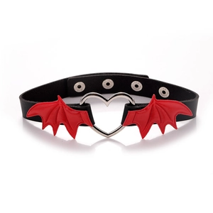 Detail of black leather choker with silver heart ring and red bat wings on white background