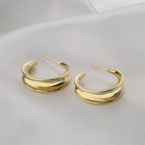 Minimalist 14K gold-plated C-shaped geometric hoop earrings on elegant white silk