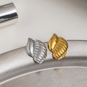 Macro view of textured snail shell style earrings in gold and silver polished steel