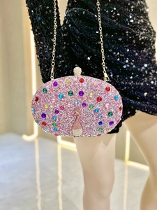 Macro detail of pink rhinestone clutch bag featuring colorful peacock gemstone pattern