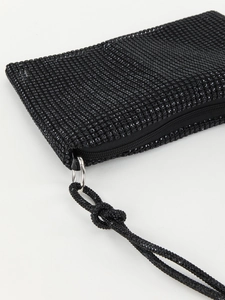 Macro view of crystal rhinestone knot bag showing shiny black texture and silver hardware
