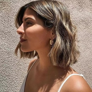 18K gold plated oval earrings with beaded texture shown on model in natural light