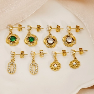 Detail view of gold titanium steel earrings with hollow designs and colorful zircons
