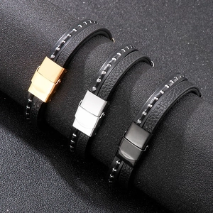 Close-up of braided leather bracelets with gold, silver, and black magnetic metal clasps